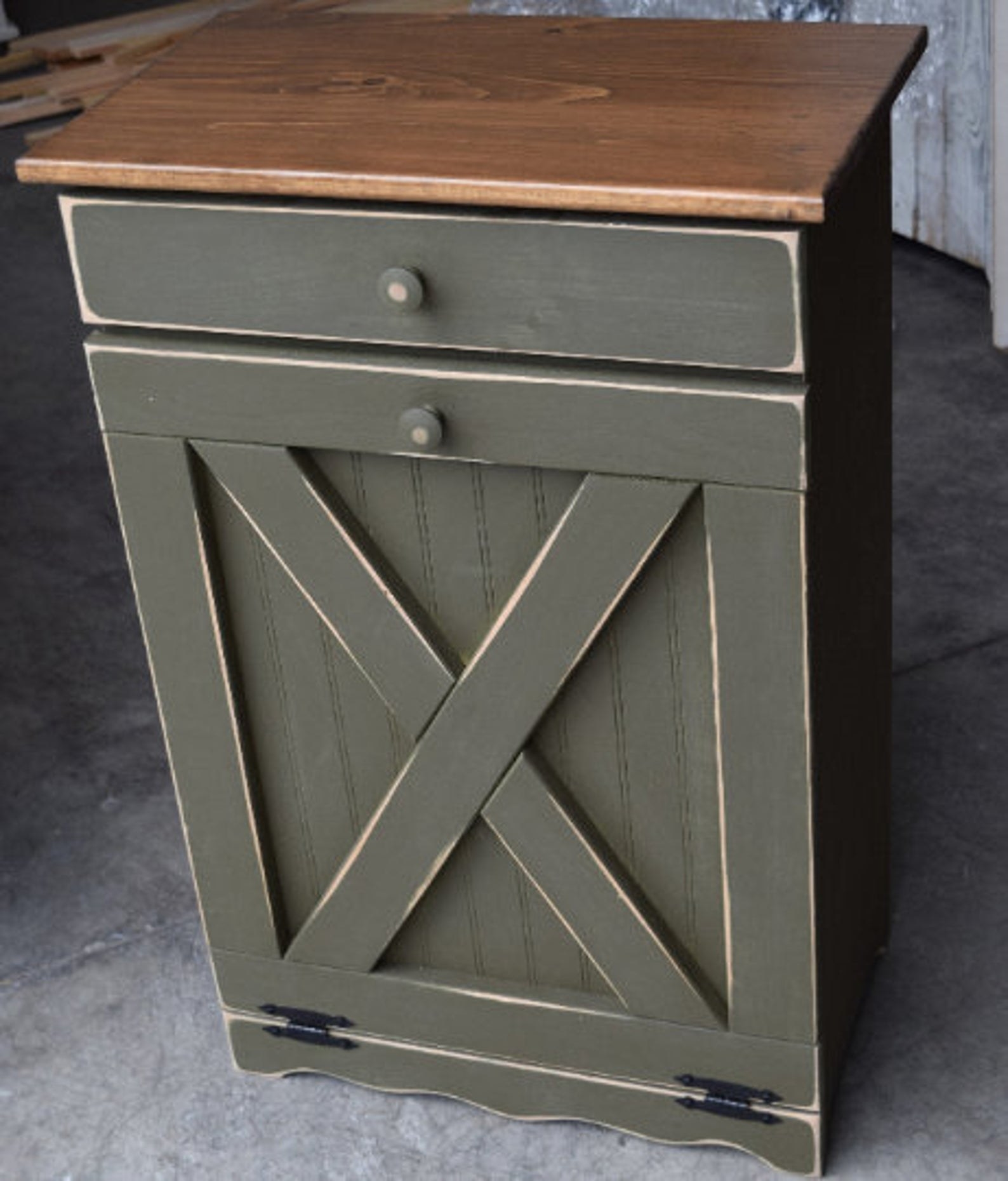 A wooden Tilt Out Trash Bin painted Antique White with Modern Walnut top.