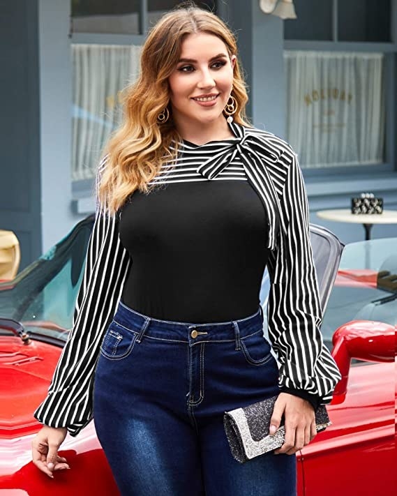 model wearing the long-sleeve blouse tucked into jeans