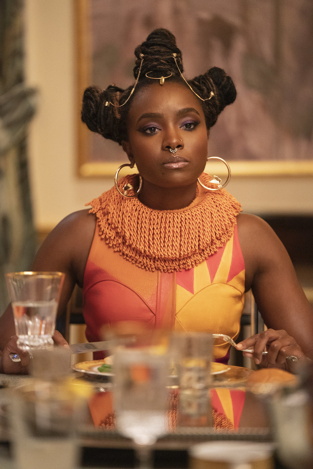 KiKi Layne sits at a dining table in COMING 2 AMERICA