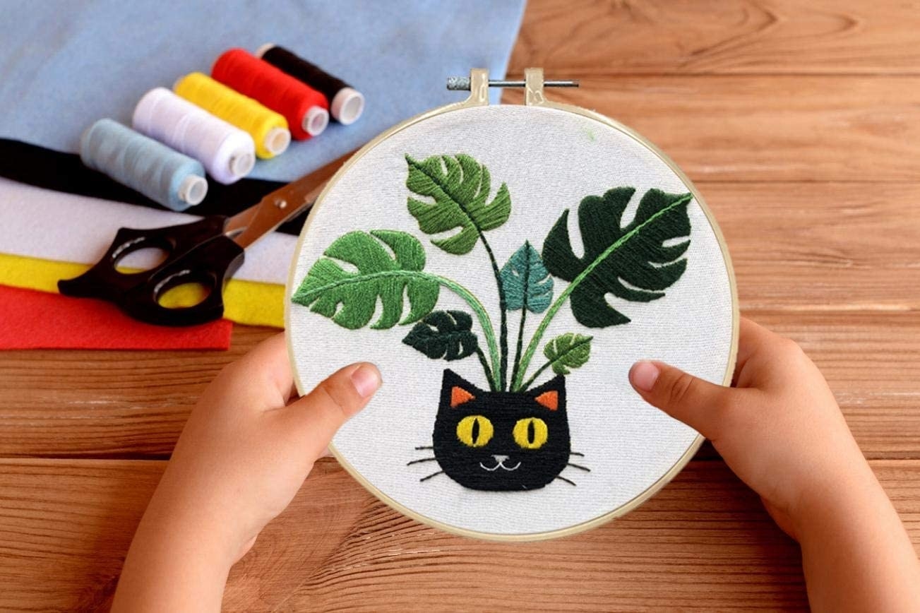 circular hoop with black cat with monstera leaf design 