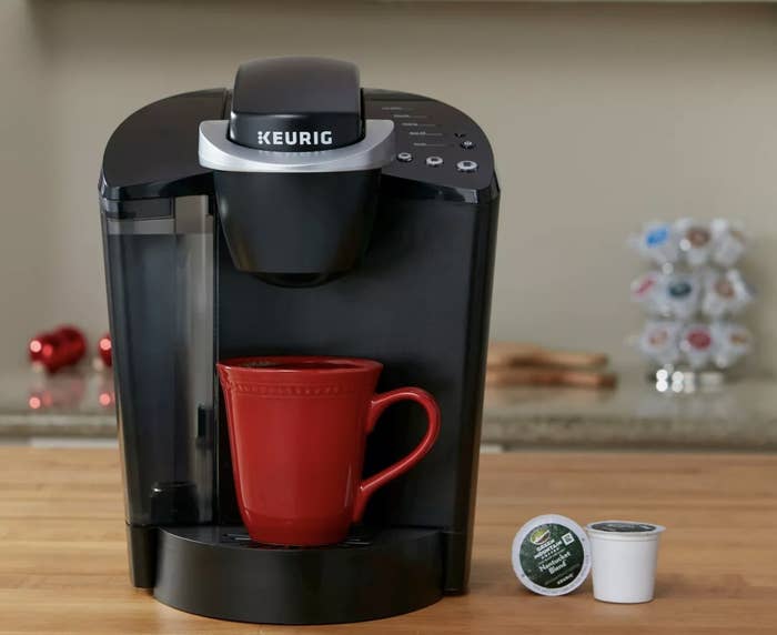 A black Keurig with a red mug