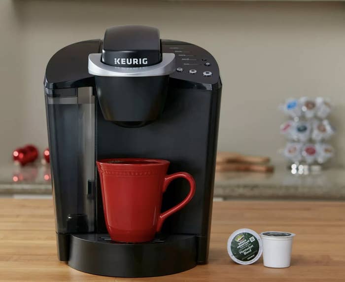 A black Keurig with a red mug