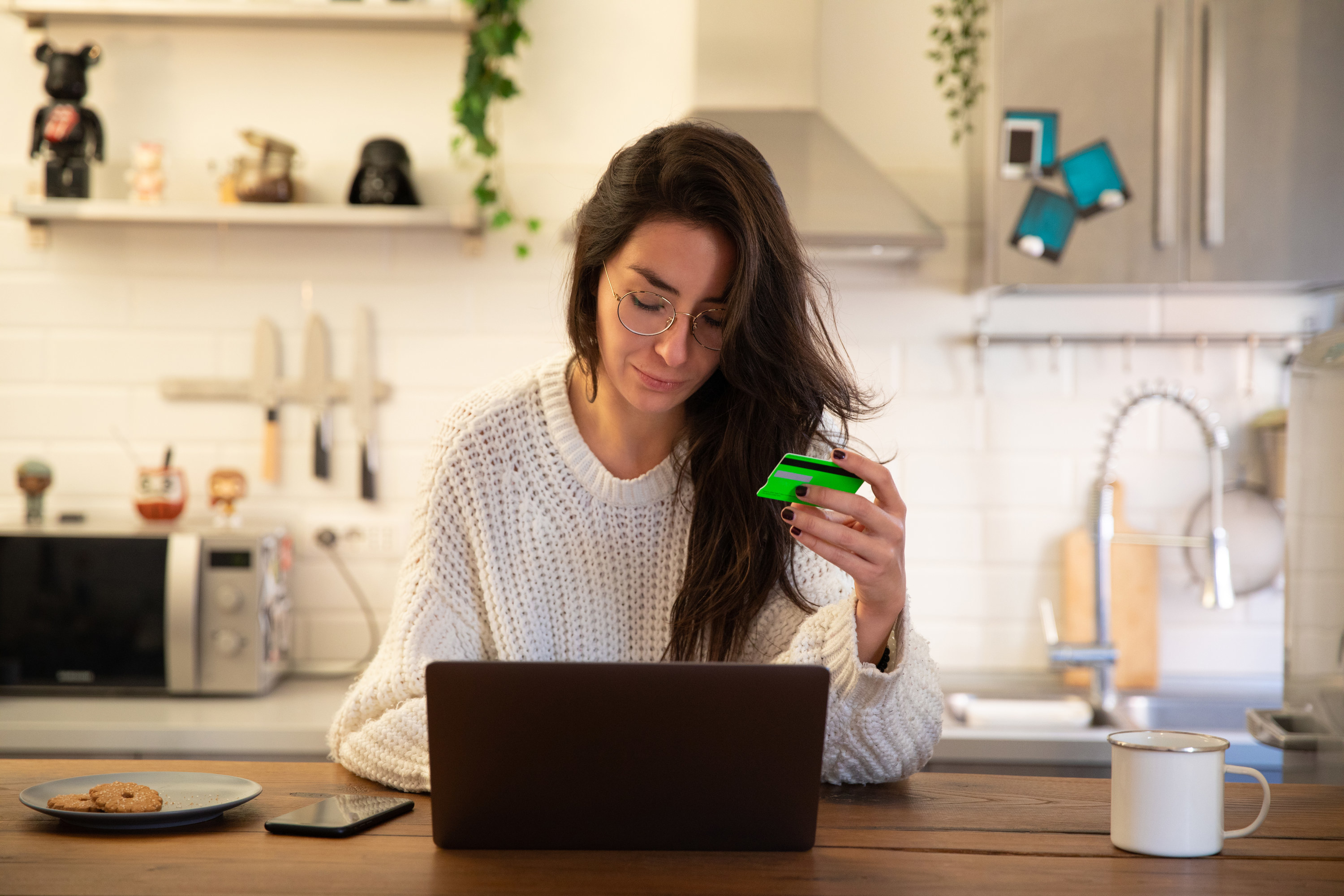 Women holding credit card while using laptop