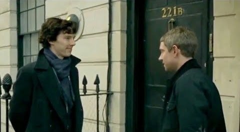 Sherlock and Watson standing in front of 221B Baker Street