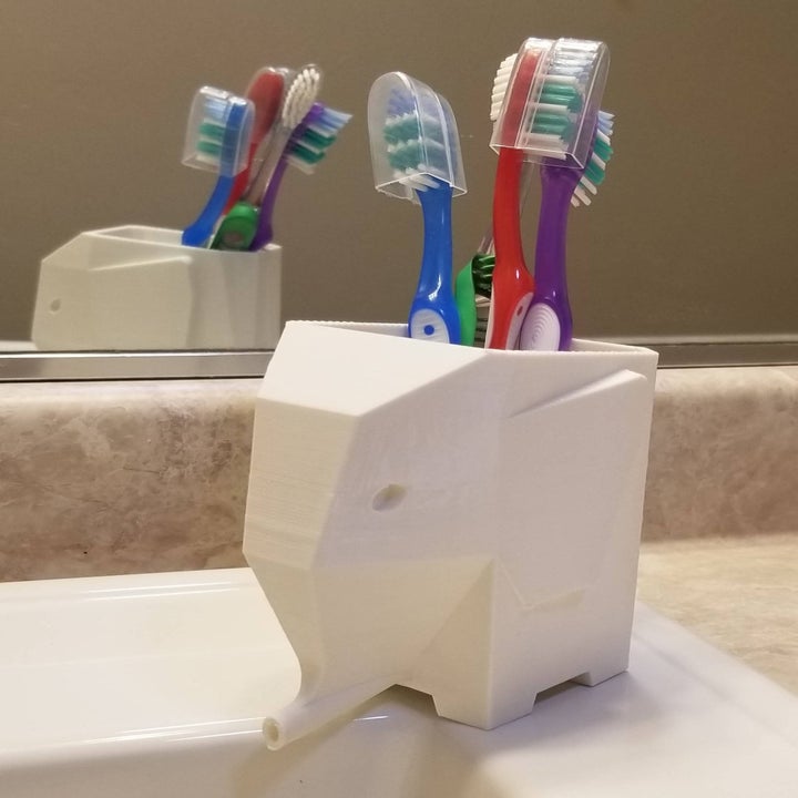 Elephant-shaped toothbrush holder with toothbrushes inside