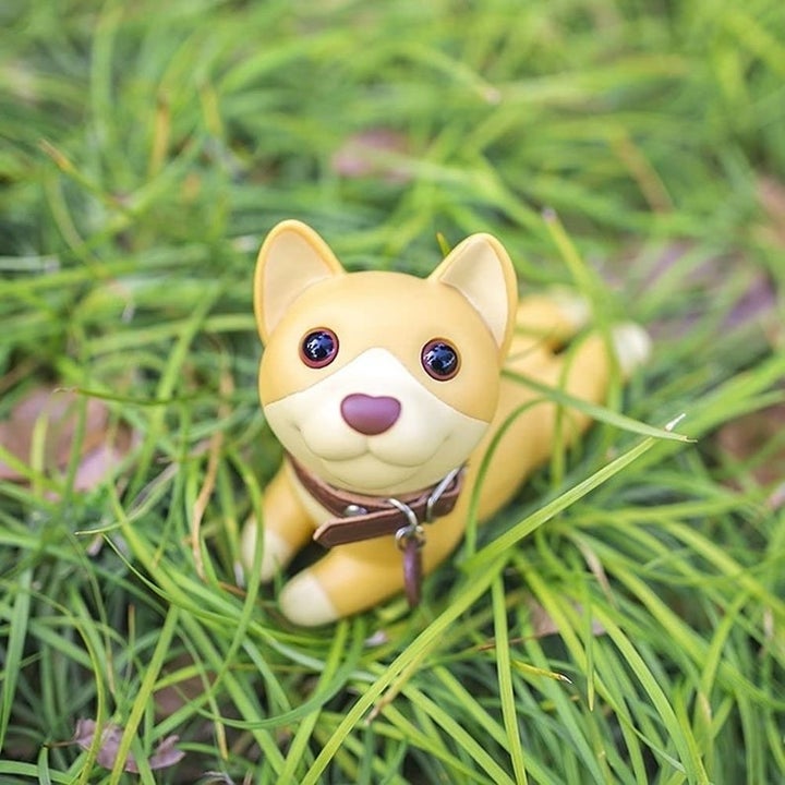 Puppy-shaped door stopper in grass