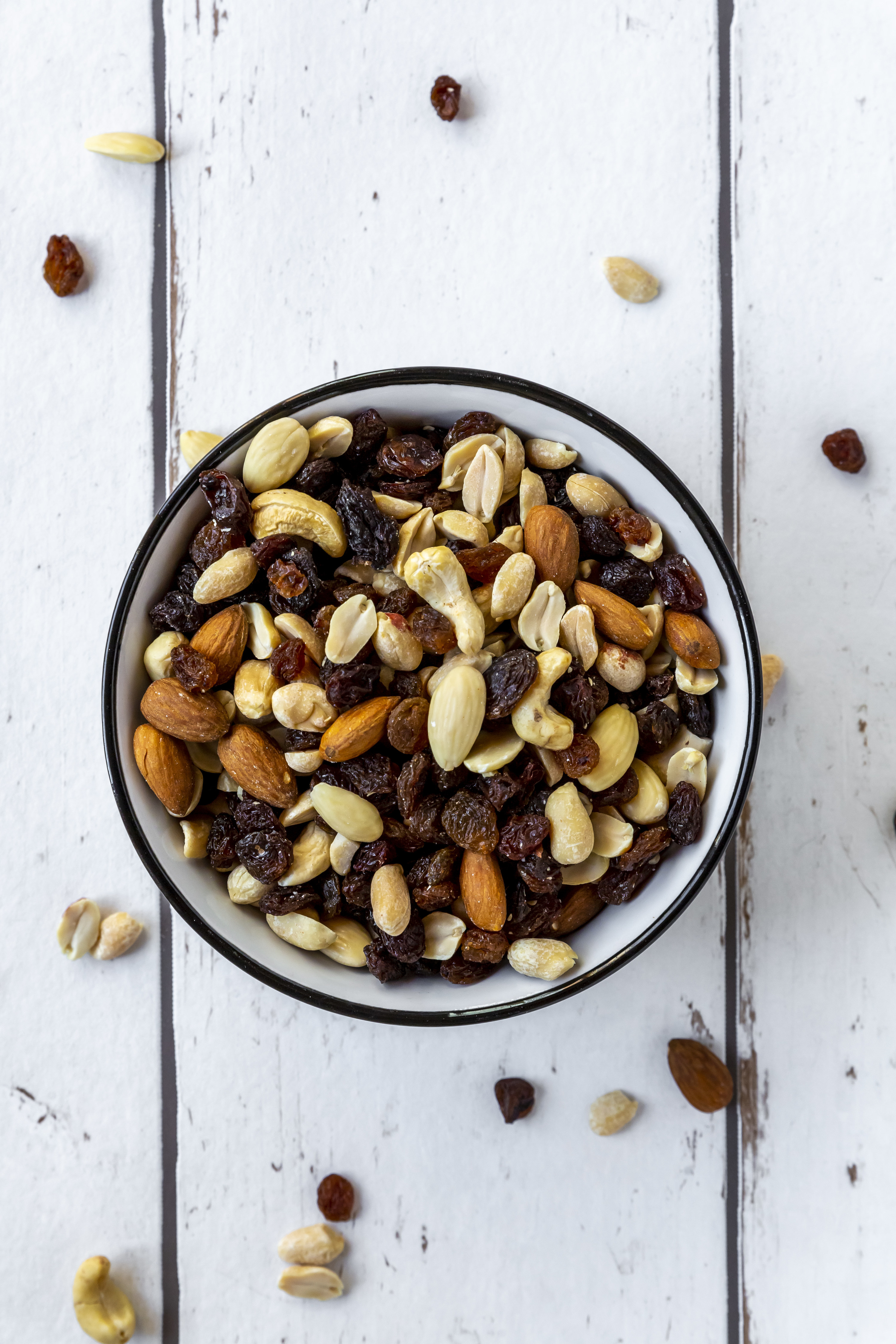 A bowl filled with peanuts, almonds and sultanas  