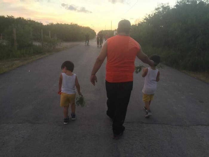 A group of people walking down a road away from the viewer