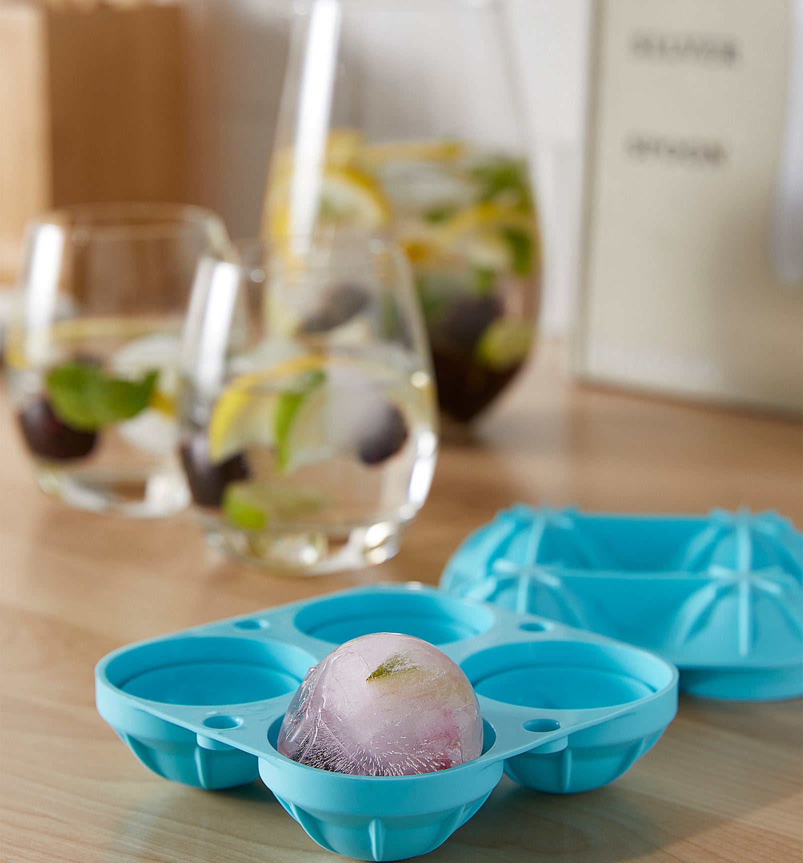 A silicone ice cube tray with a round block of ice in one slot