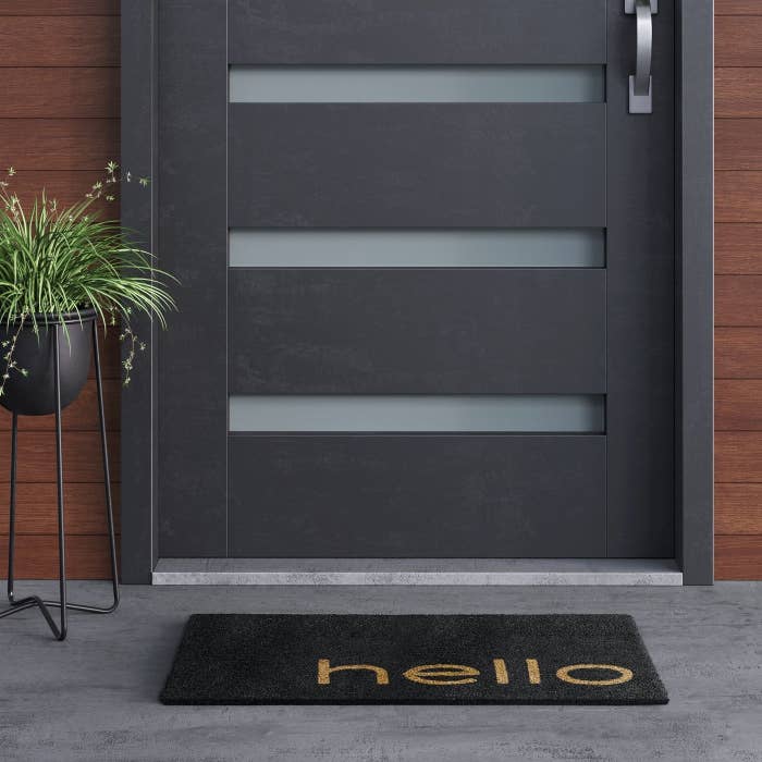 black welcome mat with brown writing