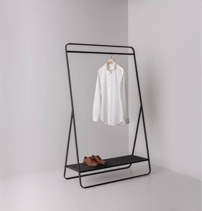 Black garment rack with brown shoes and white button-down