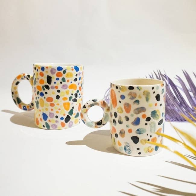The cream mug with multi-colored speckles and a circle handle