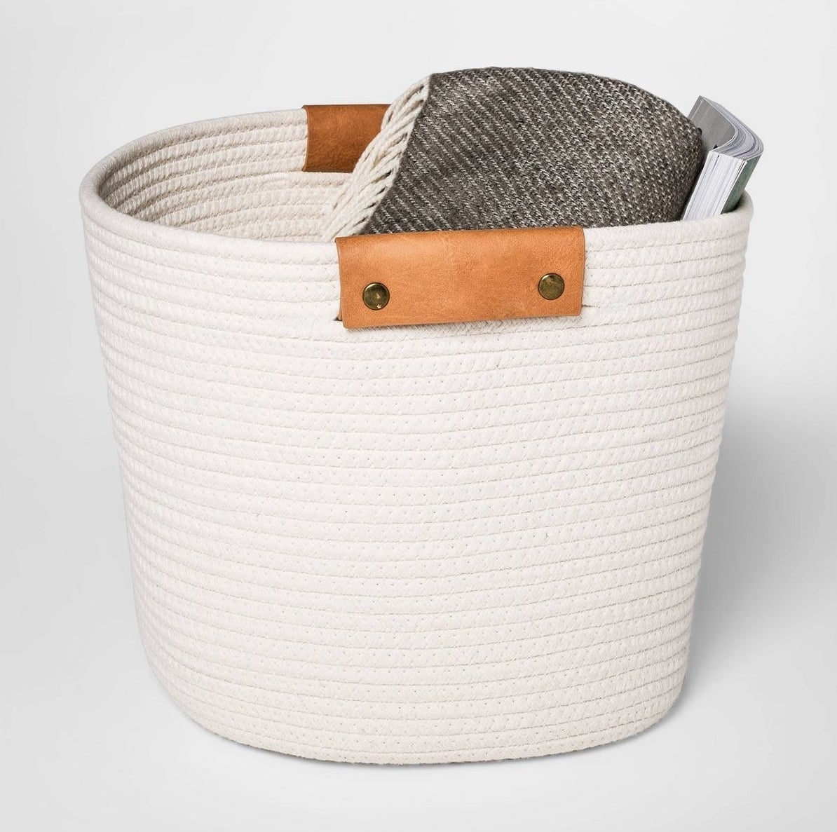 cream-colored woven rope basket with camel-colored handles