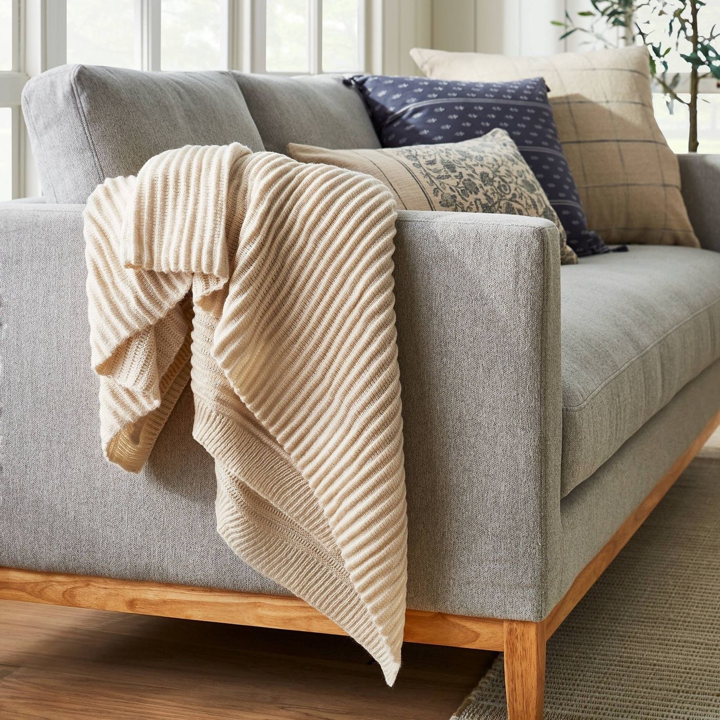 cream colored ribbed knit blanket draped on a couch