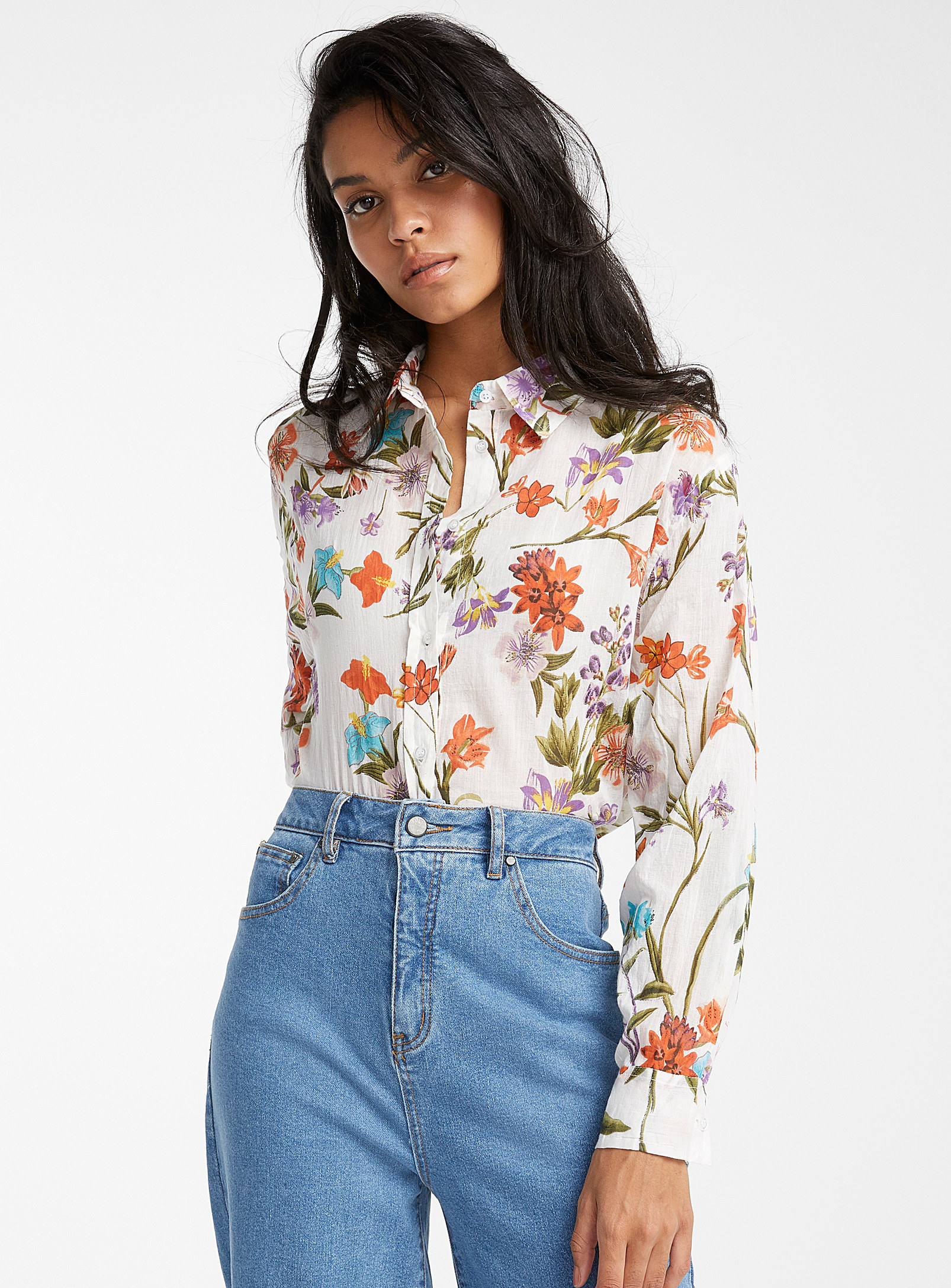 A person wearing the floral button up tucked into jeans 