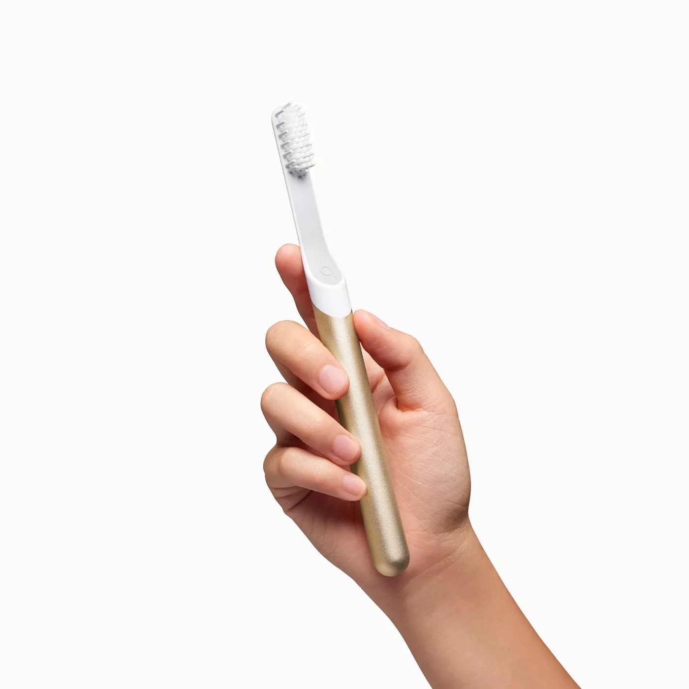 a model holding a gold electric toothbrush