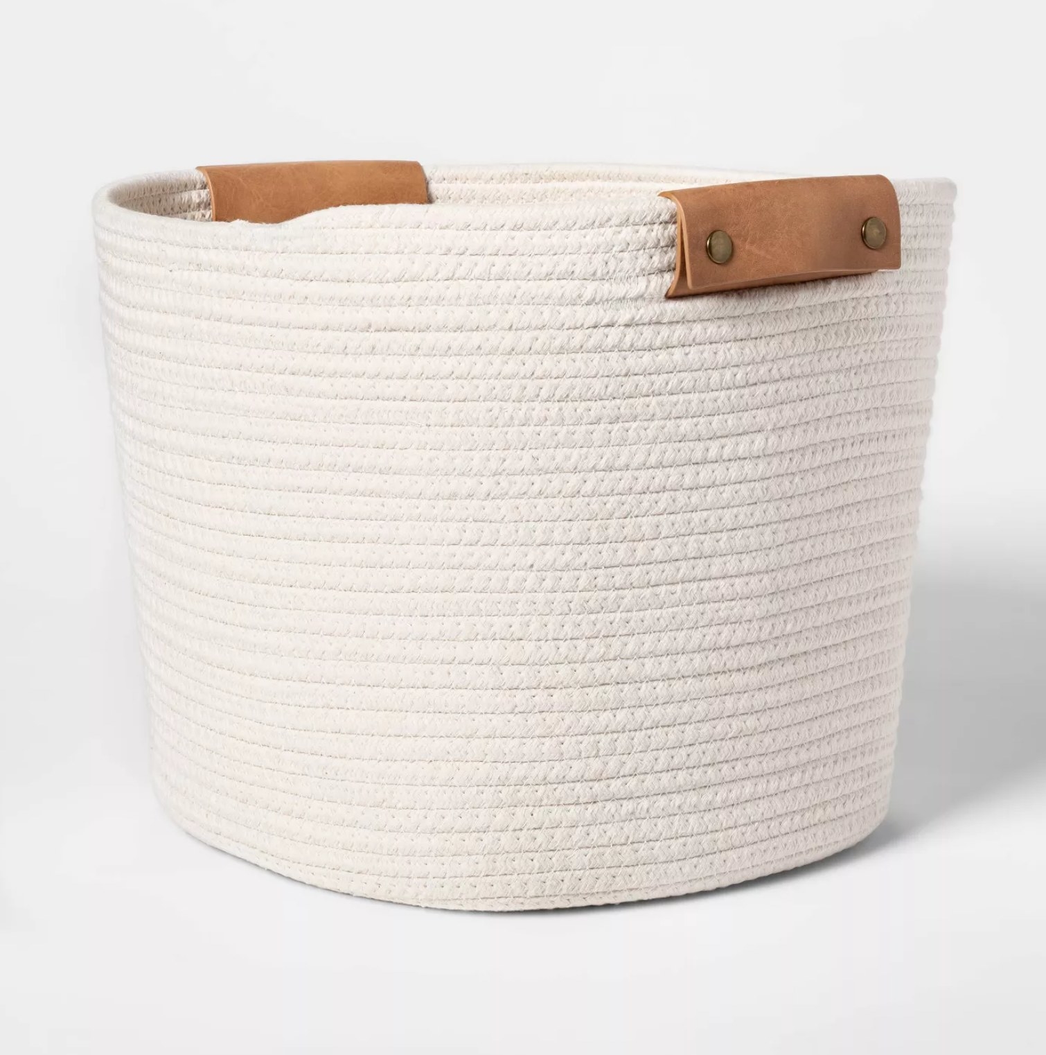 The white basket with brown leather-like details
