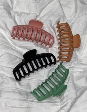 A customer review photo of four claw clips lying on a white surface