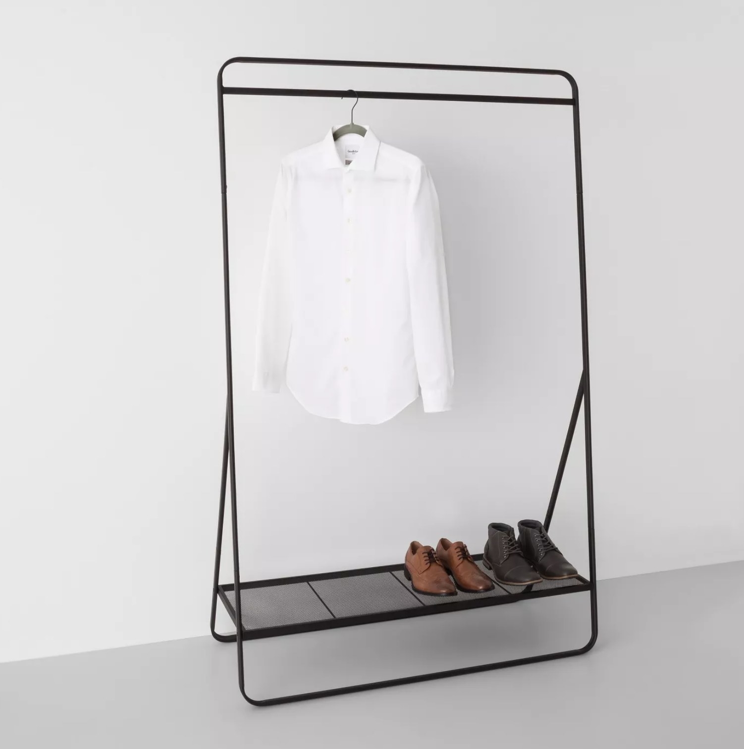 The rack with a hanging shirt and shoes on the bottom