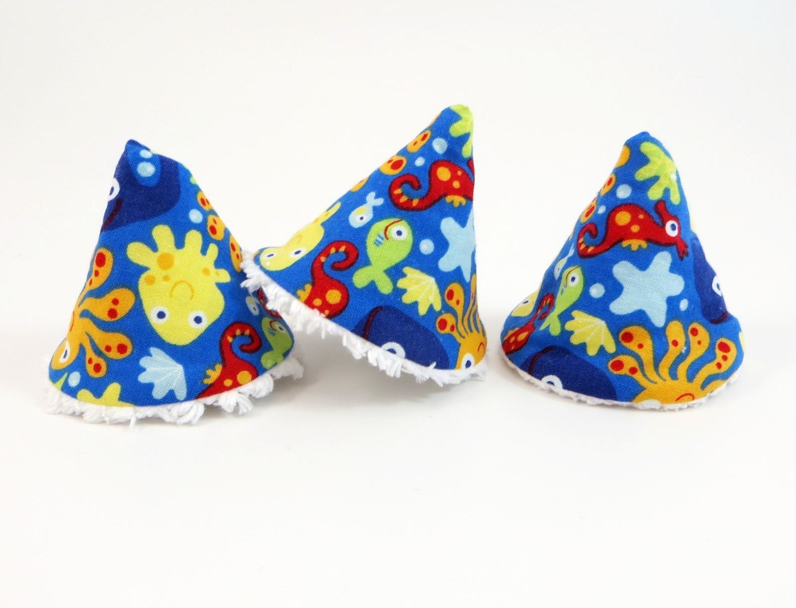 three cone-shaped covers made of fabric with a blue background and colorful sea animals all over them