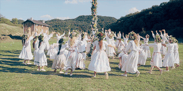 A scene from Midsommar of people dancing around a flower pole 