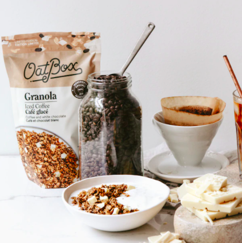 A bag of coffee-flavoured granola next to a bowl of yogurt and a jar of coffee beans