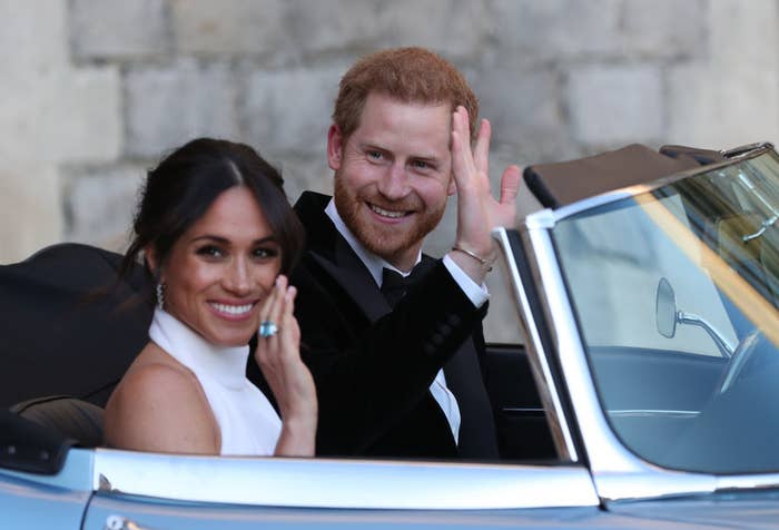 Harry and Meghan waving as they drive away on their wedding day
