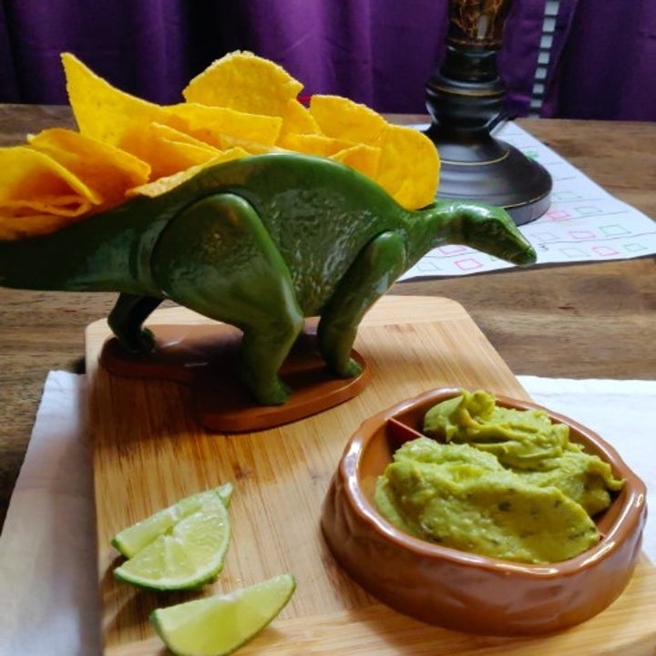 dino-shaped chip holder with tortilla chips in the spine