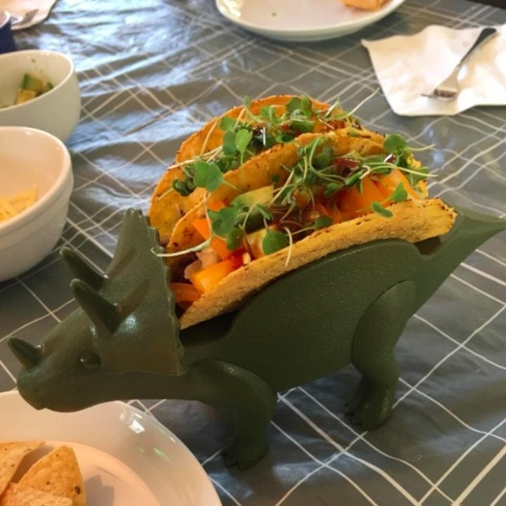 triceratops-shaped dino toy holding two tacos
