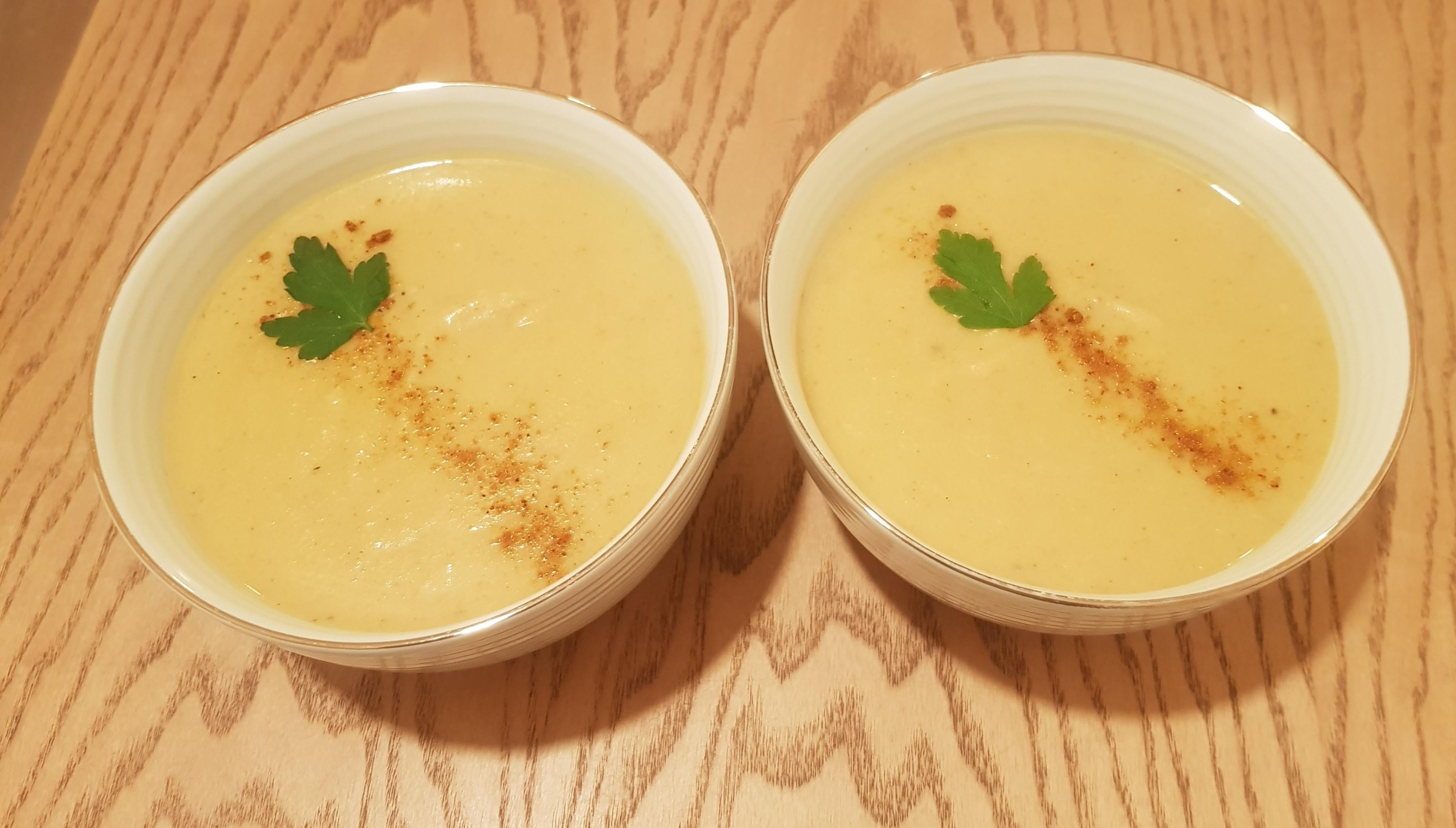 Two bowls of curry creamy cauliflower soup.