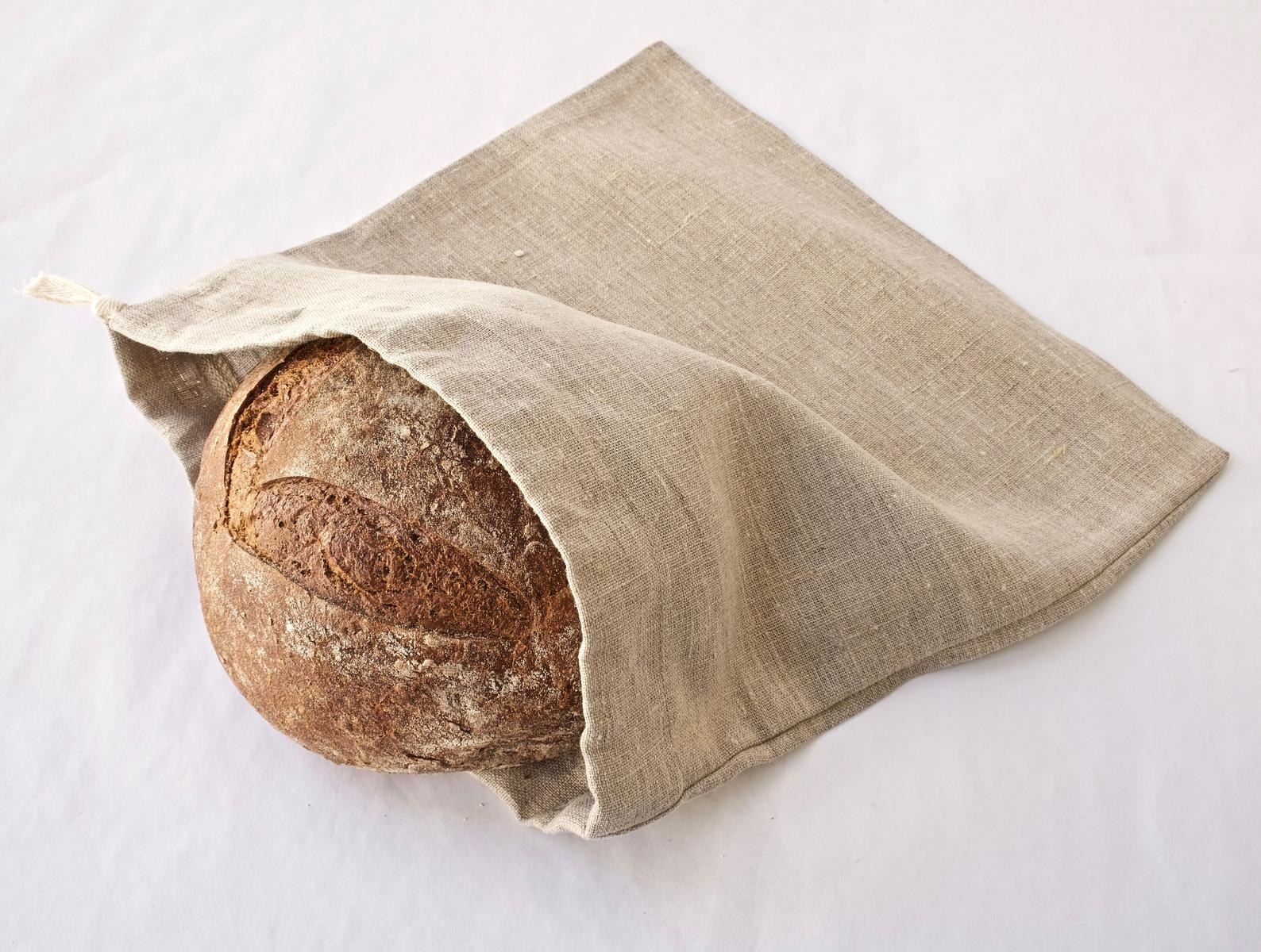 tan linen bag with a sourdough bread loaf inside