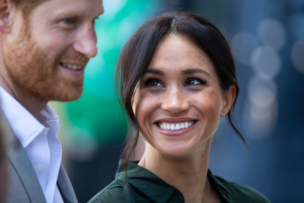 Meghan smiling widely at Harry