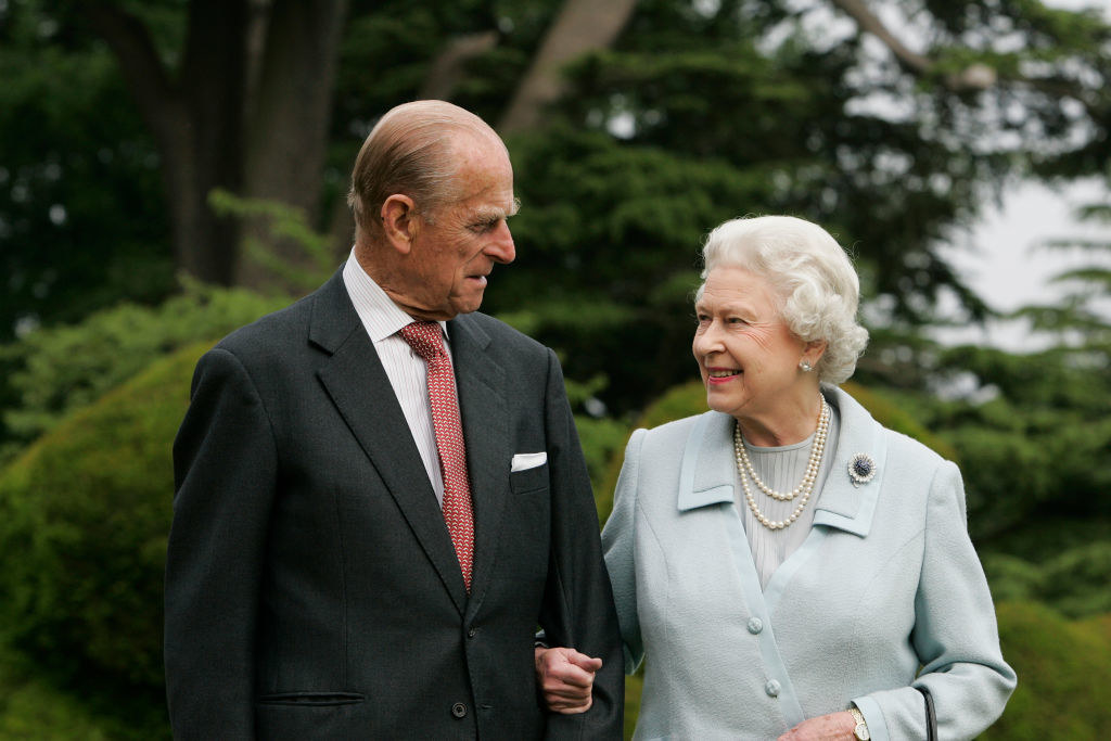 Prince Philip and the Queen standing outside arm-in-arm