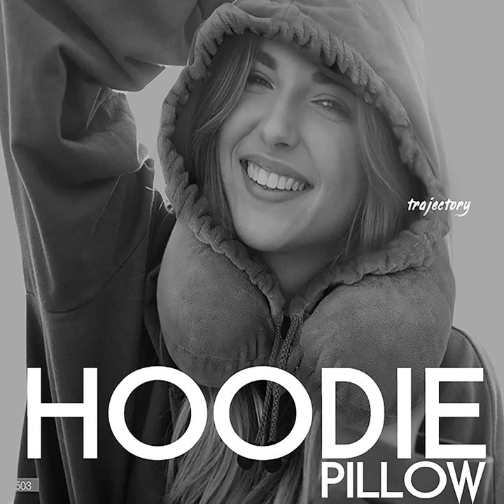 A woman with the grey hoodie and neck pillow on 