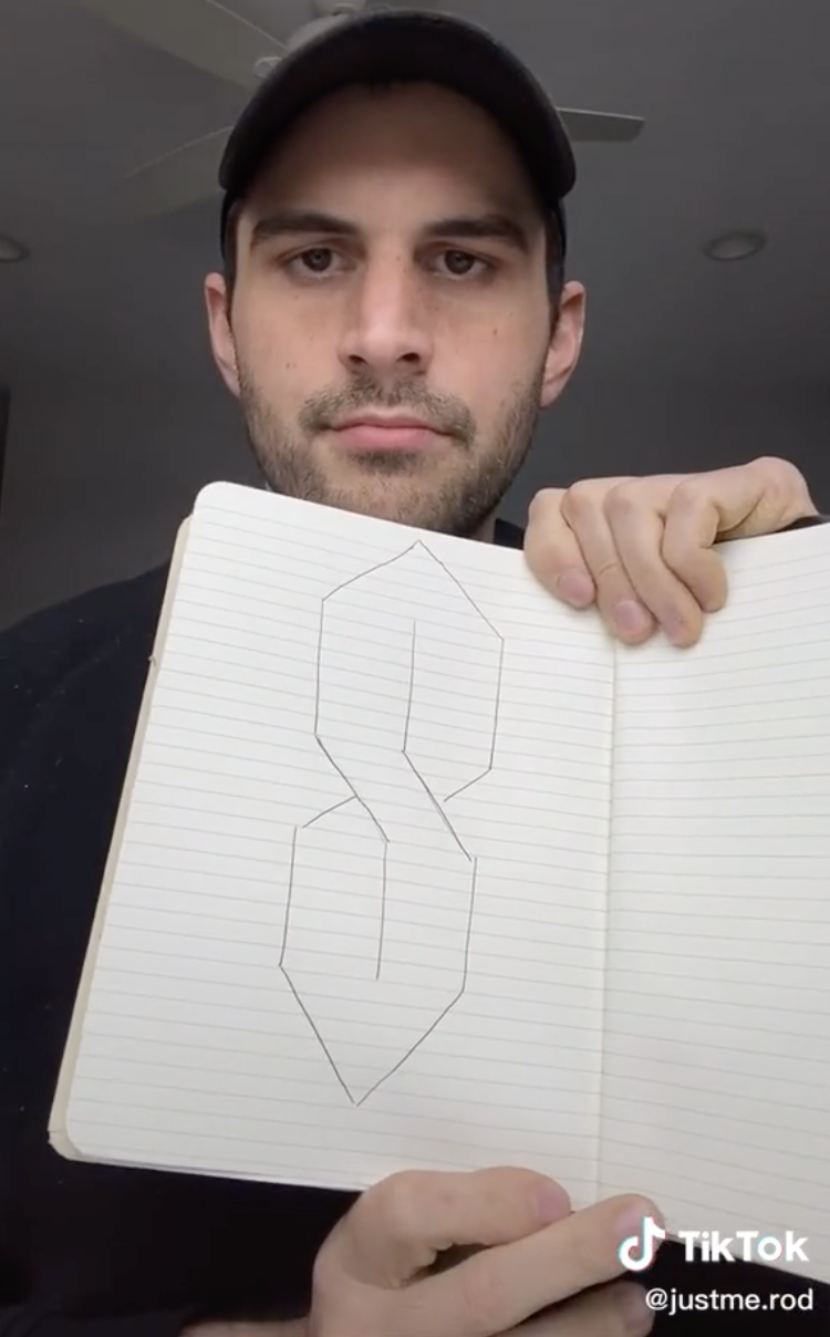 Man holding up a drawing of the letter S