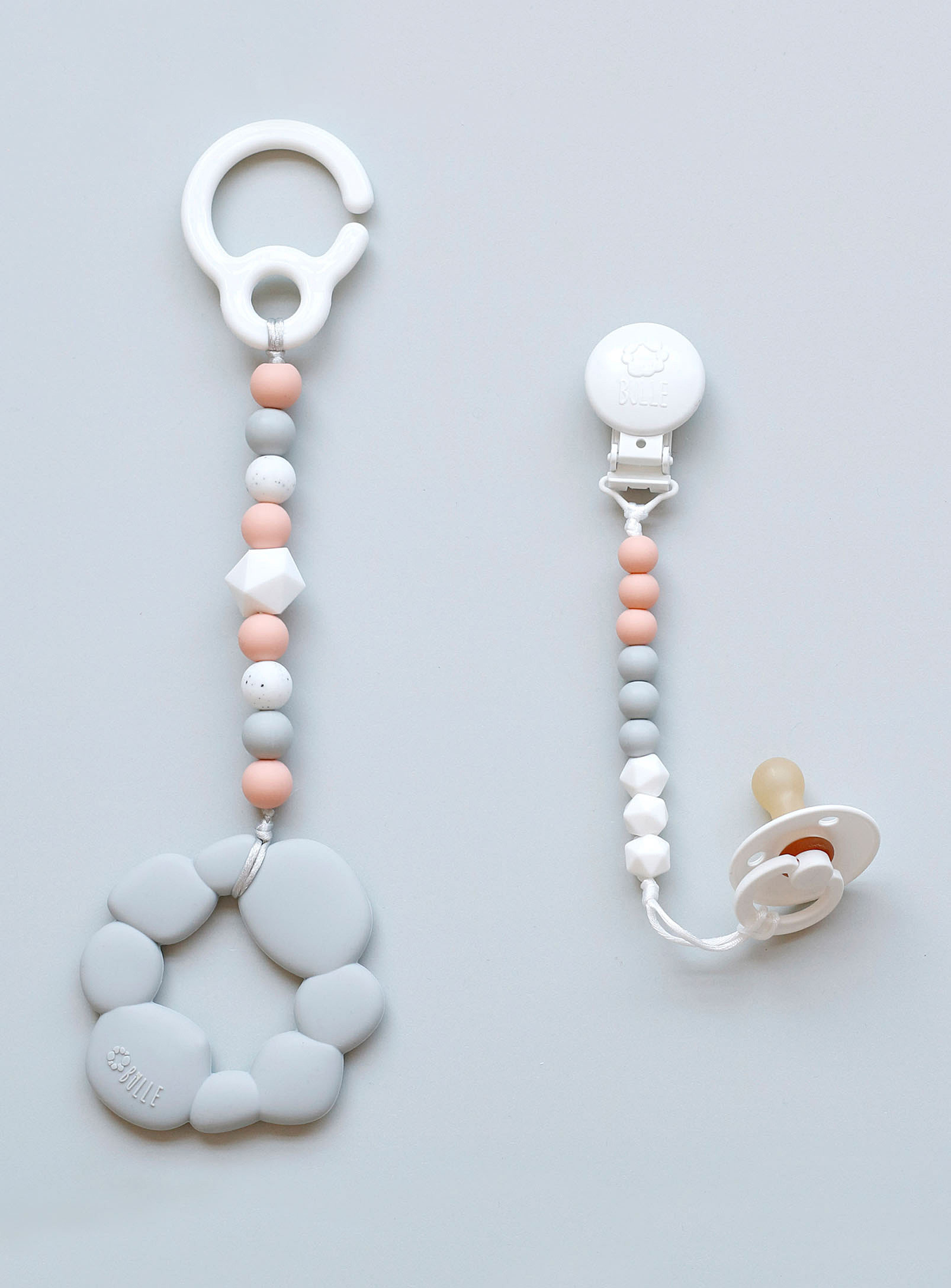 Two chains of round silicone beads with a pacifier tied to the end