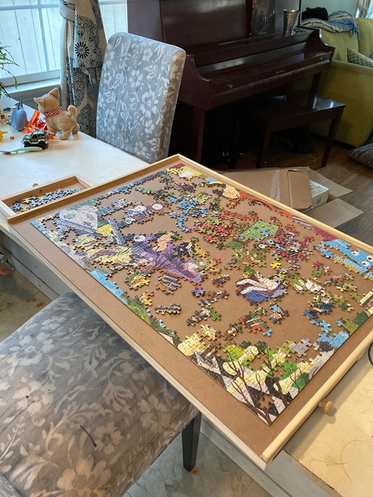 Puzzle board with partially completed puzzle on it and puzzle pieces in the drawers