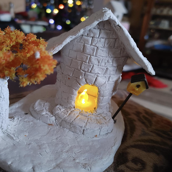 reviewer photo of model clay home with tiny tea light inside