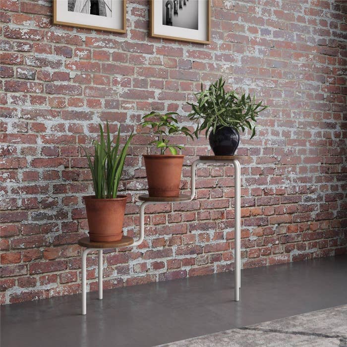 A 3-tier brown and white plant stand