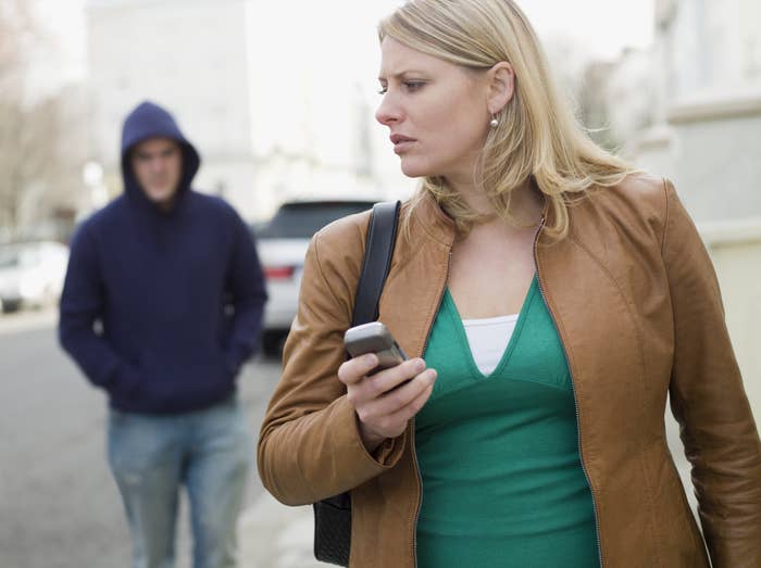 a woman on the street looking uncomfortable by a man behind her