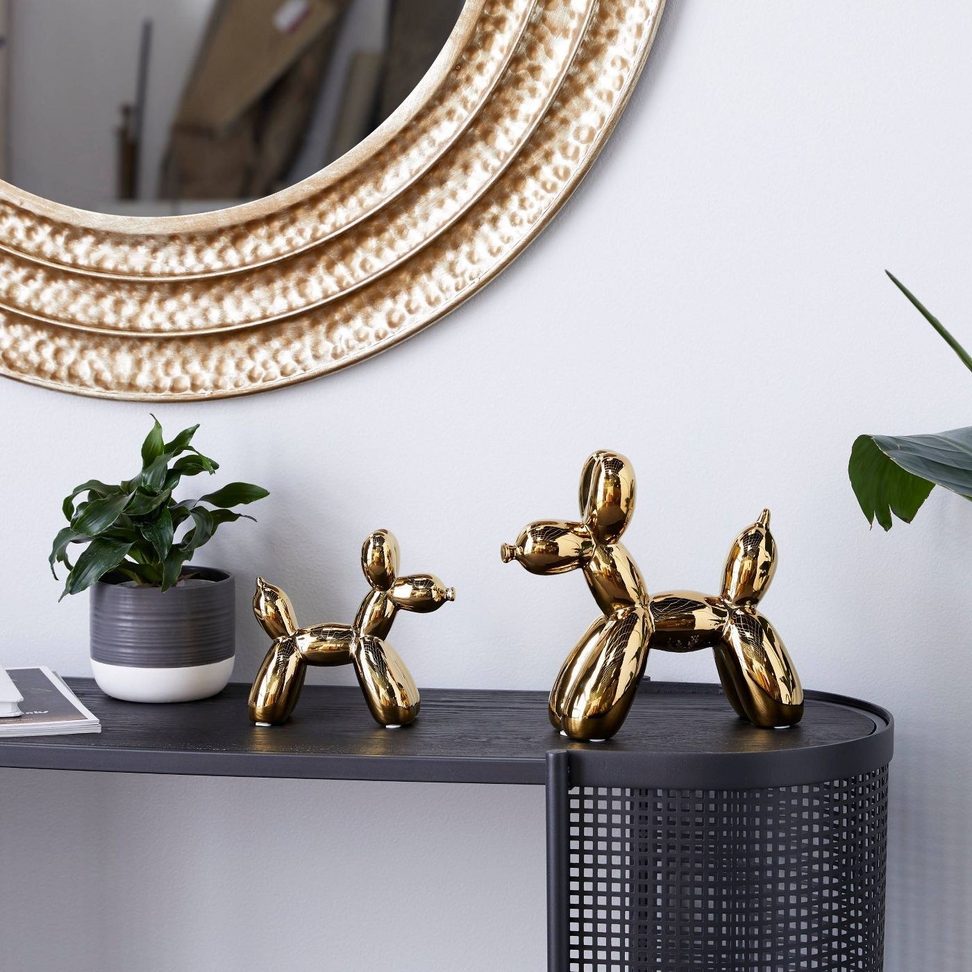 A set of gold balloon dogs on a black table