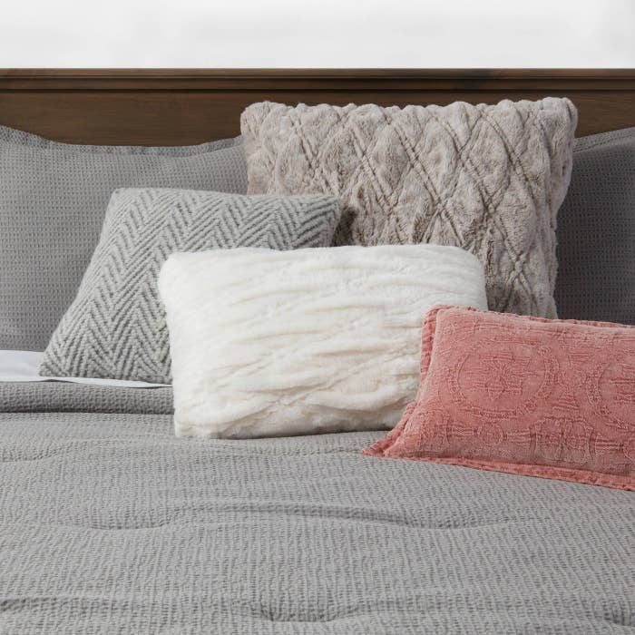 A white pillow with a pink and neutral pillow