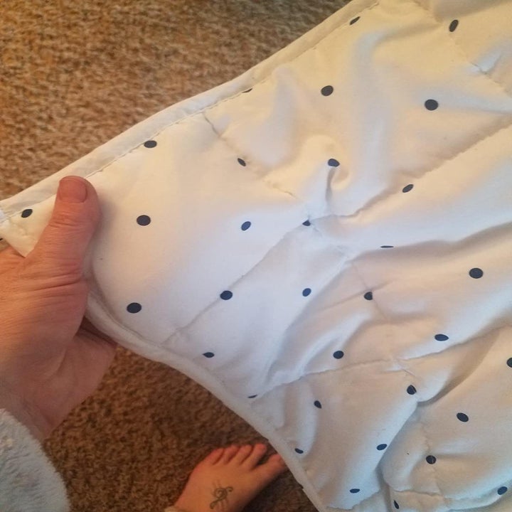 Reviewer holding the white and blue polka dot blanket