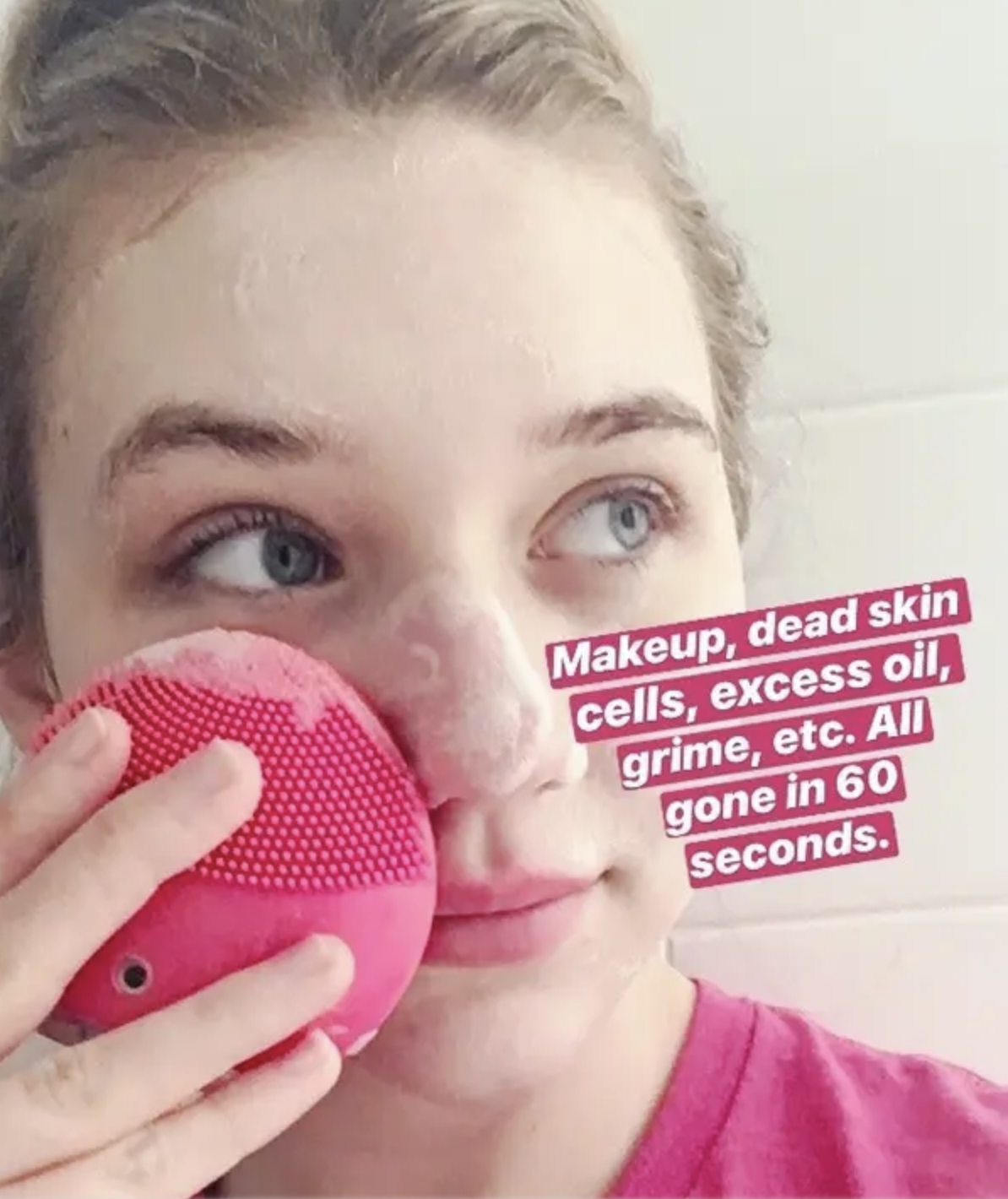 BuzzFeed editor using small pink silicone face washing device with text &quot;makeup, dead skin cells, excess oil, grime, etc. All gone in 60 seconds&quot; 