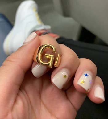 reviewer holding up ring with letter G
