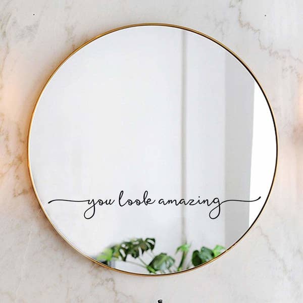 script decal that says &quot;you look amazing&quot; on a circular gold mirror