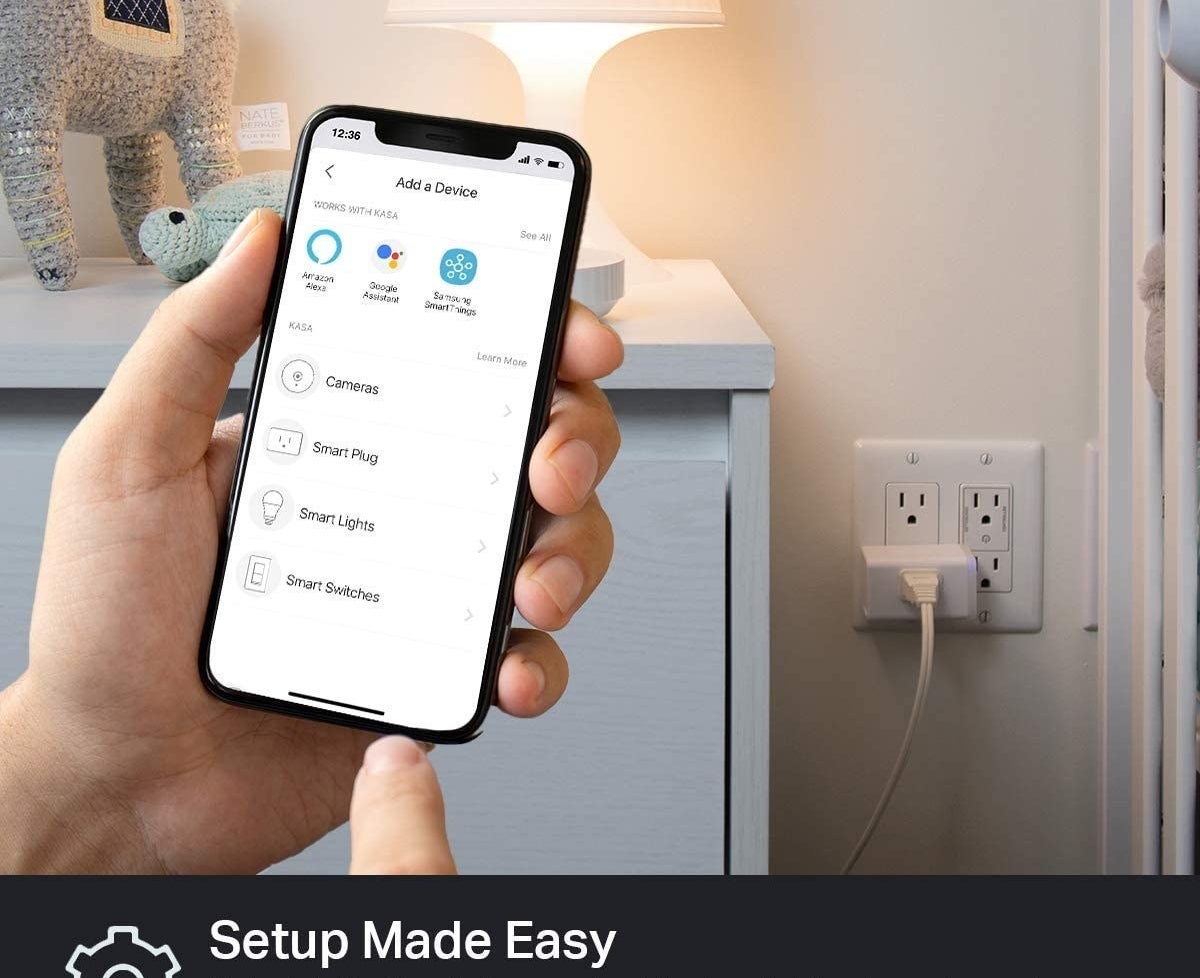 person using their phone to control the smart plug which a lamp is plugged into