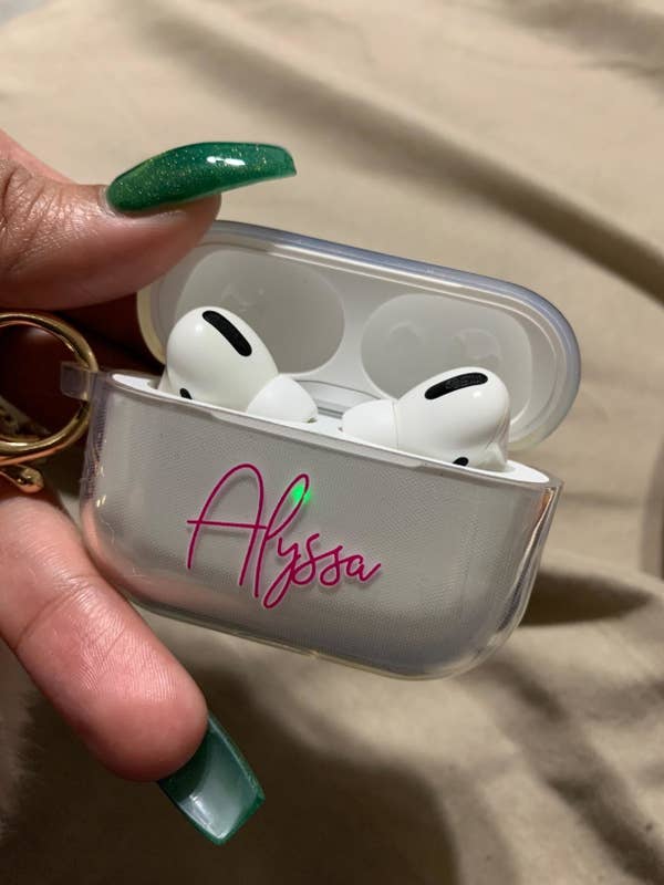 hands hold silver AirPods case that says &quot;Alyssa&quot; on front in pink letters
