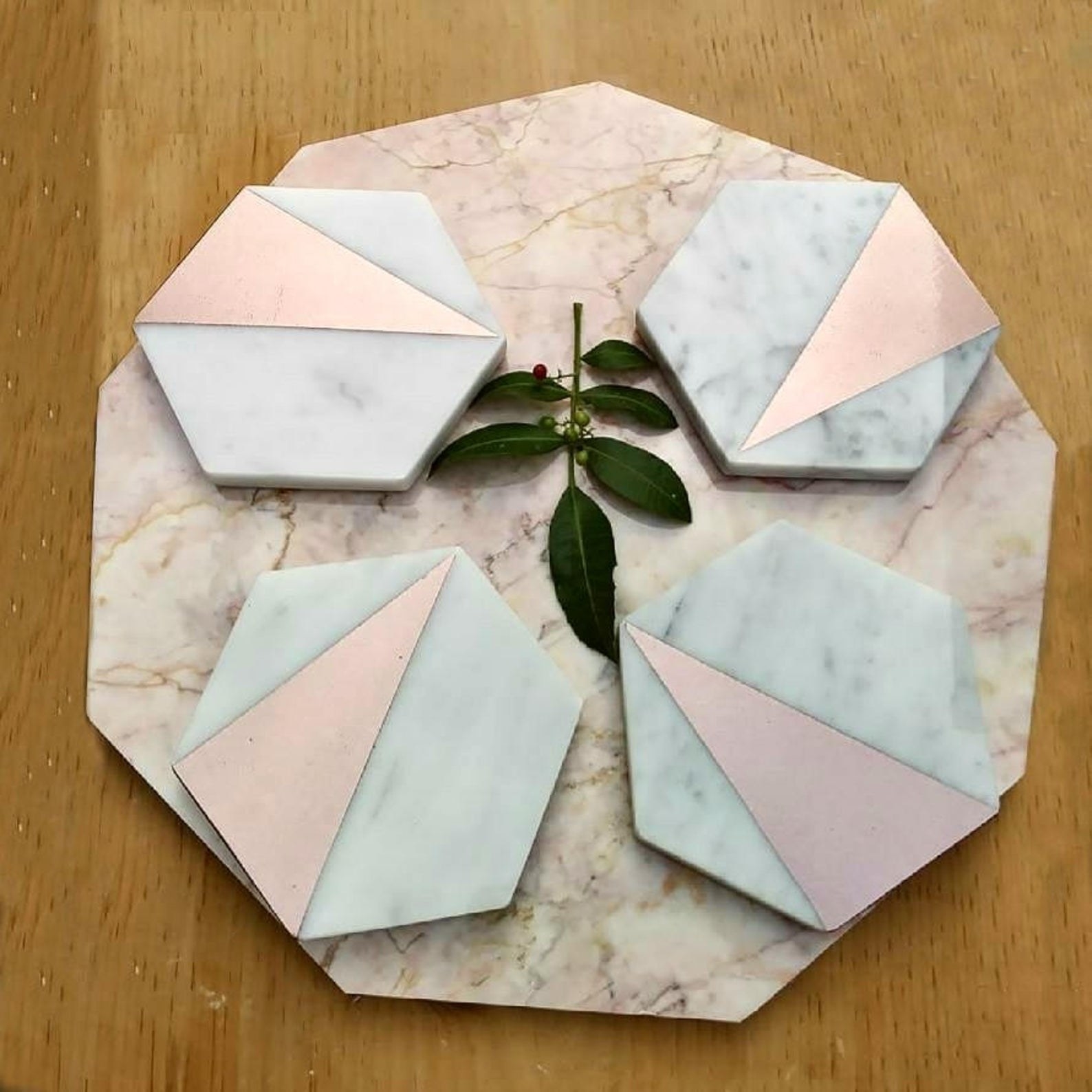 Four rose gold coasters placed on table