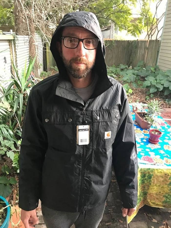 reviewer wearing Carhartt rain jacket in black 